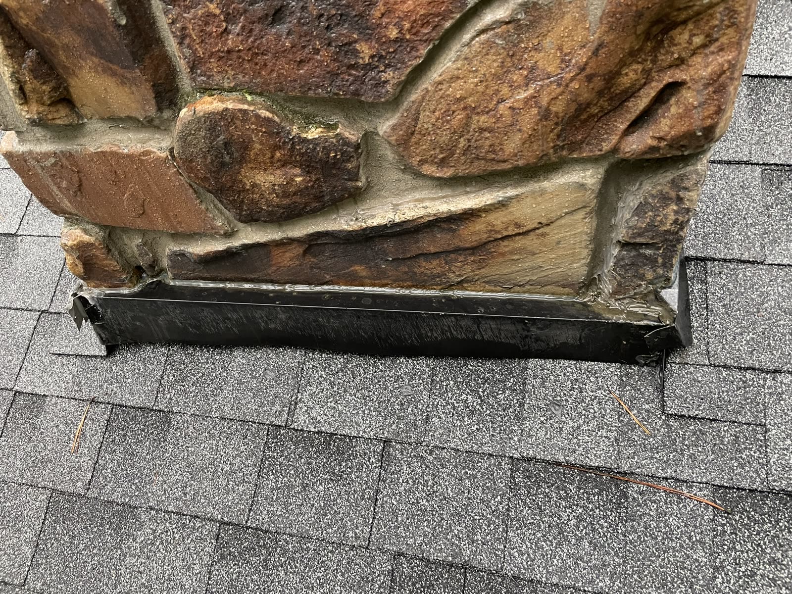 Completed flashing repair at a stone chimney on a Ketron residential roof